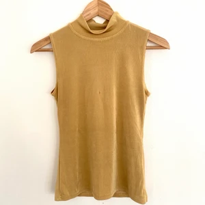 Guldig polo - Guldig polo i jätteskönt tyg! Har fått ett pyttelitet brännmärke eller liknande, som ser mörkare ut på bild iom glansen från tyget.🐱