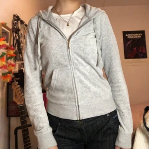 Juicy couture kofta grå - Ljusgrå juicy kofta med coolt guldigt tryck på ryggen. Materialet ser knopprigt och dåligt ut på två första bilderna men det är bara min kamera som är dålig. Egentligen är den relativt ny och fortfarande väldigt mjuk :) Kan frakta (köparen står för frakt) eller mötas i Stockholm