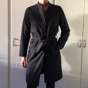 Mörkgrå kappa - Mörkgrå kappa med stråkrag från systers point.🌺🍂 Märkt storlek S Jag är 178 cm lång och har en ryggbredd på 40cm För mig är den en aningen tight över ryggen Material är ull och polyester  Inga nopprar eller fläckar