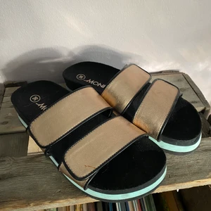 Guldsandaler - Snygga guldsandaler från Monki. Litet märke på ena bandet, se bilderna. Använda vid 1 tillfälle så i nyskick. Spana gärna in mina andra annonser för samfrakt!