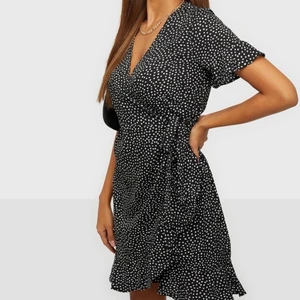 Vero Moda klänning i strl M/L/XL - Svart/prickig omlottklänning från vero Moda som försluts med knytband i midjan. Den är i nyskick. Nypris är 349kr, jag säljer för 100kr! Köparen står för frakt🤎 