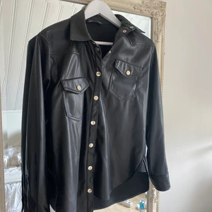 Svart skinn skjorta - Svart skinn skjorta från Zara storlek xs passar mig som bär S. Använd fåtal gånger Max 1-2 gånger. Fint skick.