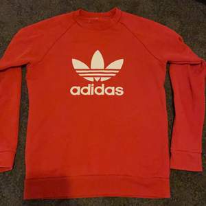 En super fin röd Adidas tröja som tyvärr inte kommer till användning, köpt för längesedan och använd mycket men ändå i bra skick! Lappen i nacken är avklippt då den skavde men annars är är den super! Skulle säga att det är storlek S-M