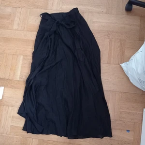 Många vart skjol storlek 34  - En lång svart skjol med en rosett vid midjan. Är från gina tricot och är knappt använd. (Kontakta mig för frakt pris) 