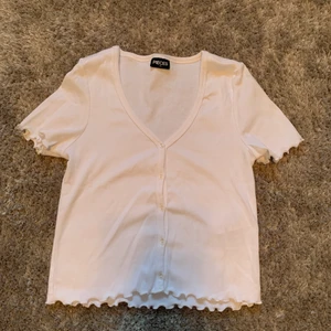 Vit t-shirt med knappar - Vit gullig t-shirt med knappar. Aldrig använd i storlek XS.