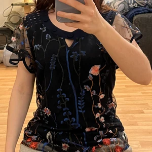 Topp - Blommig topp/blus med lite detaljer runt hals och axlar.  Storlek M skulle säga S/M då den är lite tight över axlarna :)