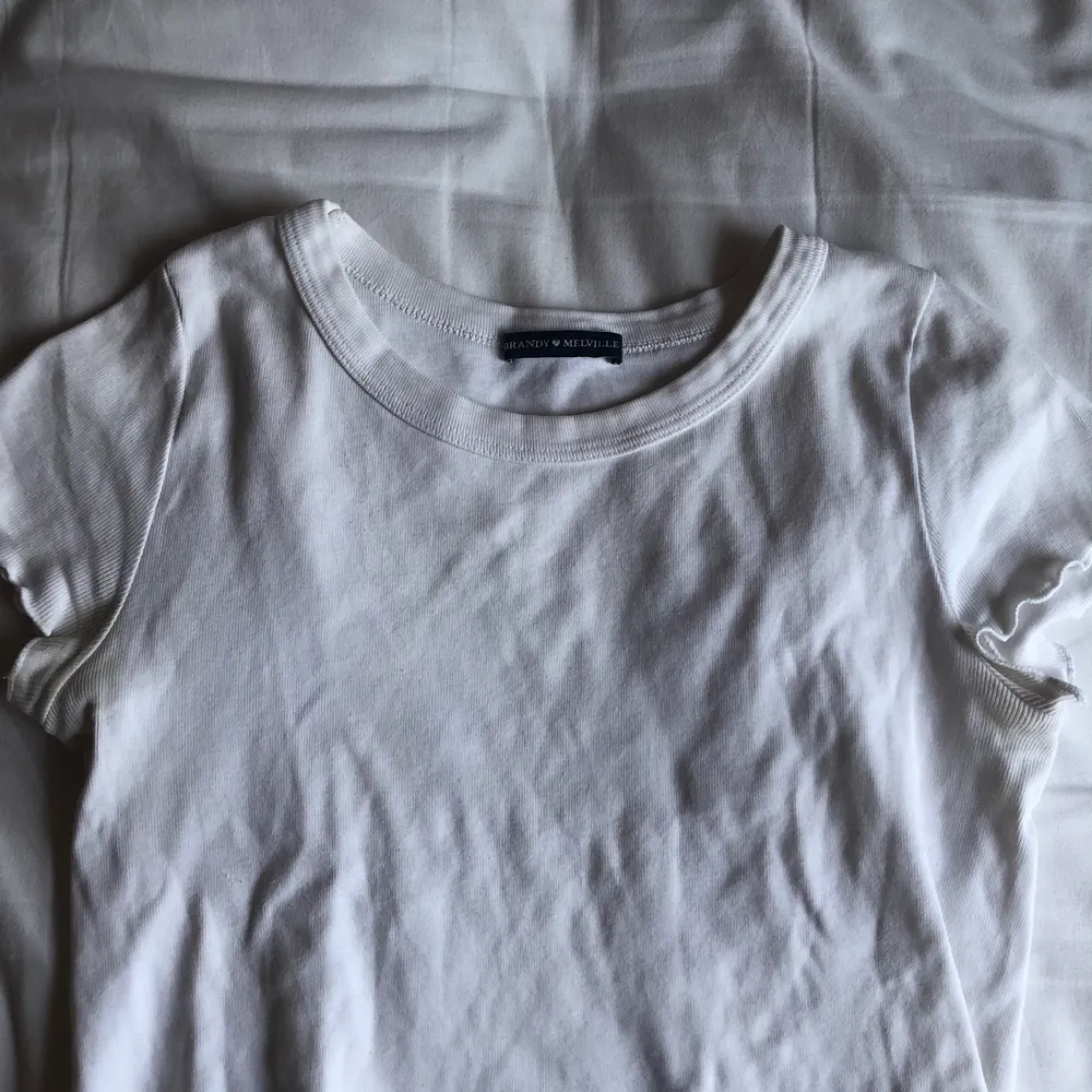 Kroppad vit t-shirt som är räfflad nertill från Brandy Melville.. T-shirts.