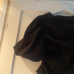 Svart blus med puffärm  - Svart blus med puffärmar, festlig och skönt material.