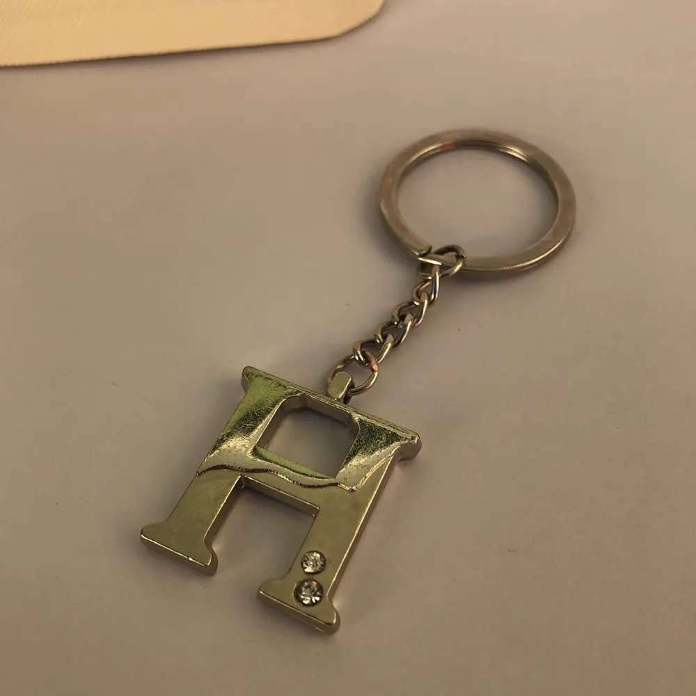 Superfin ”H” nyckelring med två små diamanter. Köptes i en souvenirbutik. Frakt tillkommer. Skriv gärna vid frågor 💙. Asusteet.