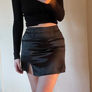 Trendig svart kjol i satin, säljer pga att den är för liten för mig🥺 Har dragkedja i sidan och en liten slits över vänster ben. Jag är 172 cm. Köparen står för frakten🤎