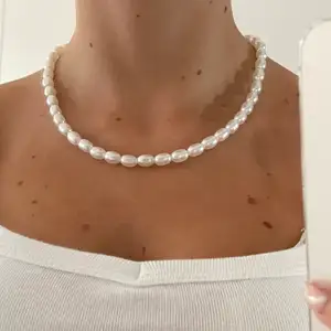 Väldigt fint och simpelt halsband med vita ovala stora pärlor- Halsbandet är 40cm. Tillkommer spänne och ringödlor som gör att halsbandet kan justeras efter önskad storlek.