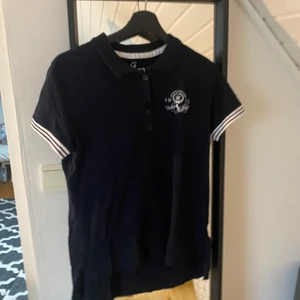 Rid-tshirt ifrån hööks! - Säljer min rid-tshirt ifrån hööks då den ej kommit till användning. Endast provad. Tvättas självklart innan köp! Den är marinblå med vita detaljer och i storlek M!🥰 pris kan diskuteras. Köpt för 300 o säljer för 120kr