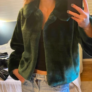 Fuskpälsjacka  - Säljer denna gröna fuskpälsjacka från weekday! Den är några år men knappt använd så ser ut som ny! Len och blank päls, den är ganska tung så känns lyxig. Den har snygga långa och stora ärmar samt är i en croppad modell!