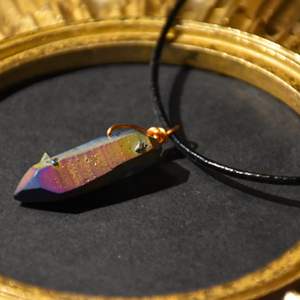 Halsband med en imitations kristall i vackra färger. Läderband ingår 