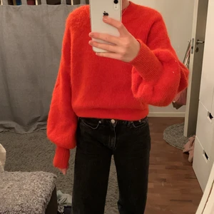 Röd/orang stickad tröja - En stickad tröja i stark röd färg. Köptes för läng sen och finns inte att köpa längre. Tröjan är i fint skick trots att jag har använt den ganska mycket. Köptes för 500kr 