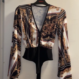 Body Gina tricot - Body från Gina, i jättebra skick har klippt bort lappen men skulle säga att den är i S/M den är rätt  stretchig!