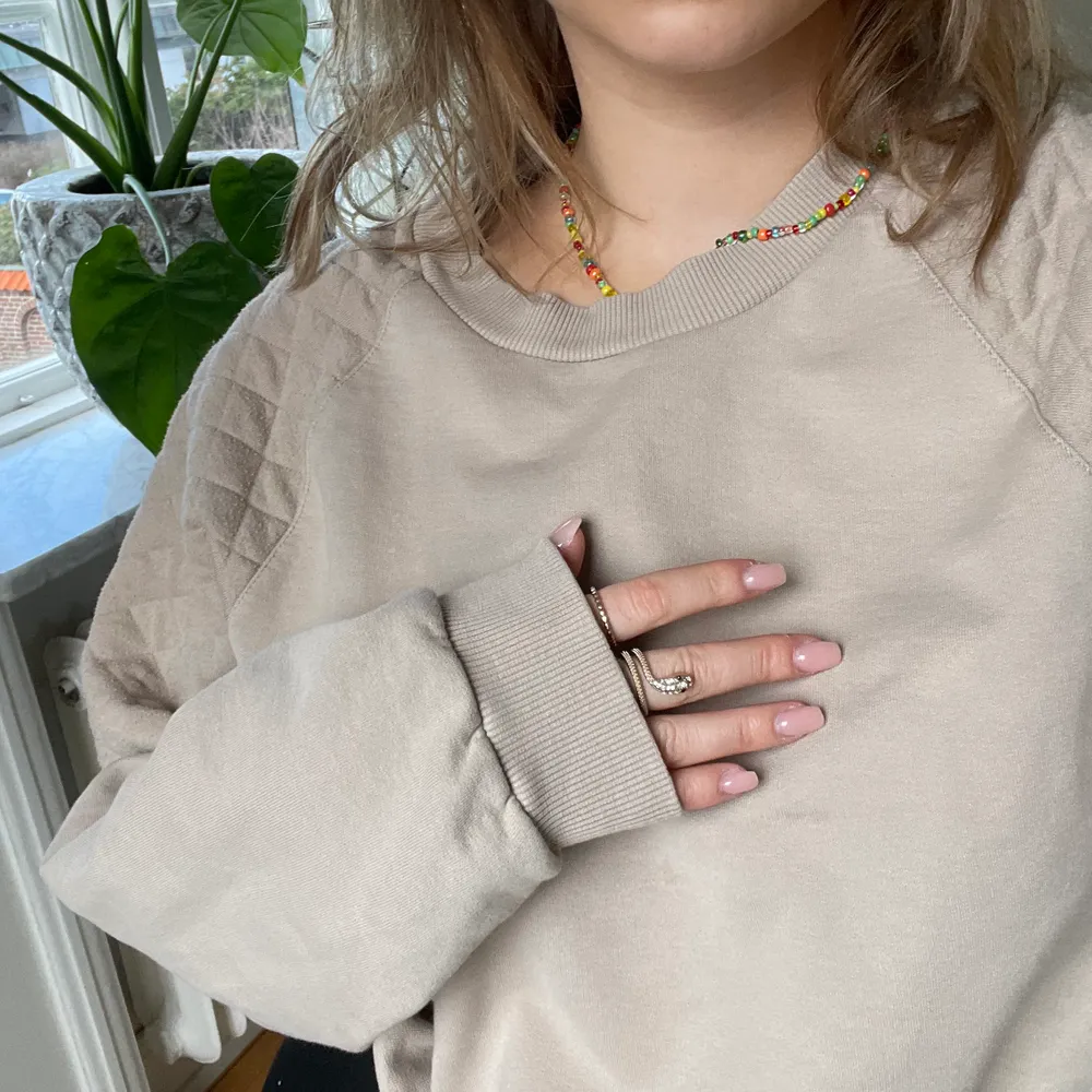 Beige croppad sweatshirt med detaljer på axelpartierna, även resor i midjan. Som ny! Passar de med storlekar mellan S-L beroende på hur man vill att den ska sitta.. Tröjor & Koftor.