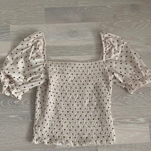 Krämvit blus/topp med svarta prickar i storlek s - Hej jag säljer min krämvits blus/topp med svarta prickar på i storlek S från Gina tricot , på mig som är 165 cm lång sitter den jättebra💖