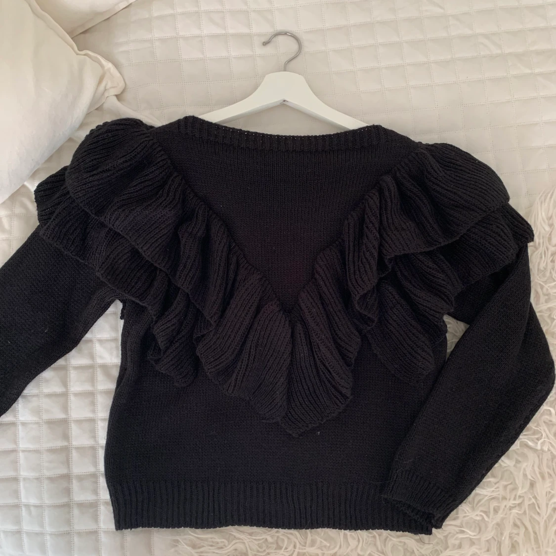 Stickad tröja med volanger