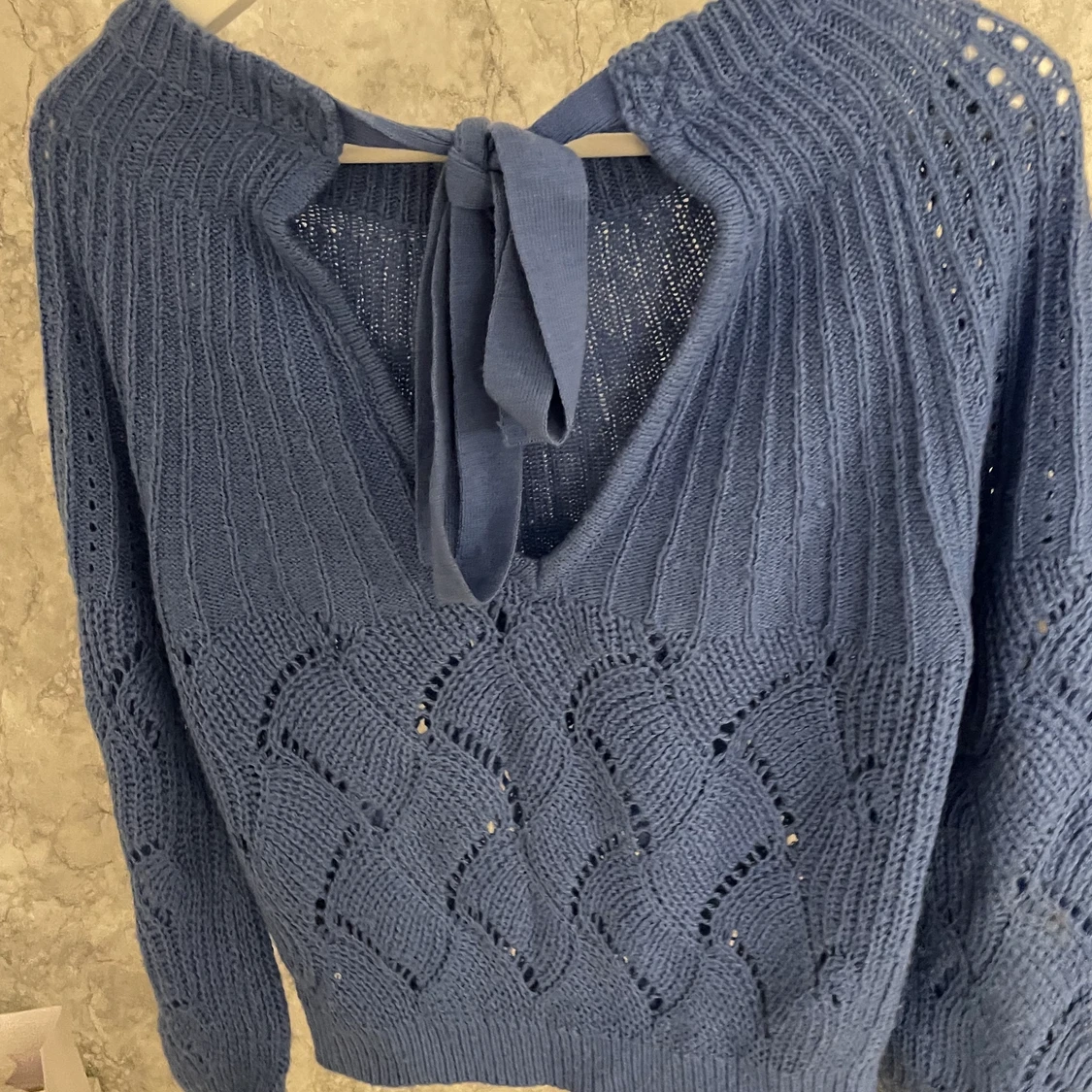 Stickad tröja med rosett i ryggen  - 90