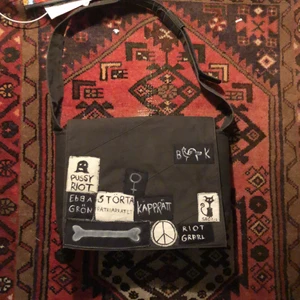 Datorväska med patches  - En datorväska dekorerad med hemmagjorda patches! Säljer pga används inte:) Får plats med Mac book och större laptops + har flera fack till pennor osv! Köparen står för frakten <33