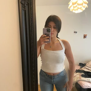 Trendig vit topp - Superfin vit topp, med öppet där bak. Trendigt just nu och jättefint med ett par jeans!