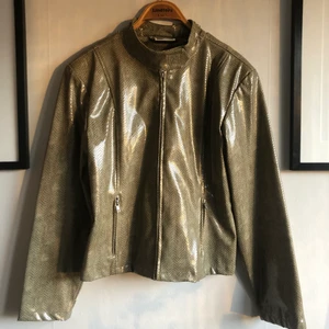 retro jacka i skinnimitation - Jacka i fake ormskinn i storlek 40/42 (jag skulle dock säga att den passar 34-38 beroende på hur man vill att passformen ska vara!) Färg: grön / beige. Märke: Crazy World. Tyvärr har materialet släppt i nacken, se sista bilden. Använd (second hand) Annars ingenting att anmärka på! 