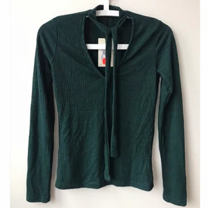 Blus från BikBok, storlek XS - Mörkgrön tröja från BikBok, storlek XS. Har knytband vid halsen. Aldrig använd, prislapp kvar 💚