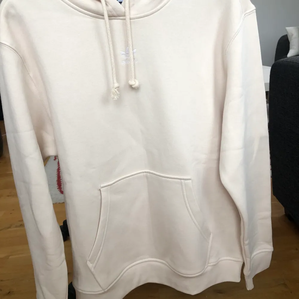 Krämvit Adidas hoodie, helt oanvänd i storlek M. Nypris 599kr Frakt 66 kr. Hoodies.