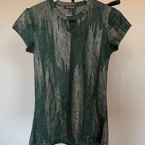 Partytopp - En mörkgrön festlig partytopp med guldiga detaljer. Superfin och användbar men har tyvärr blivit för liten. Storlek XS men skulle säga passar S! Märket är Alice Bizous och köpt på MQ. Frakt tillkommer!