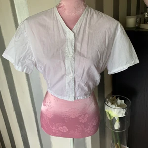 Blus vit  - Kort blus med korta ärmar super fin på. Man får en snygg siluett 