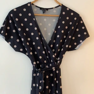 Byxdress, strl 34 - Jätteskön stretchig byxdress som sitter snyggt. Prickigt mönster, knyts åt vid midjan och vida ben. Croppade – kortare längd (jag är ca 166 cm lång). Färg: mörkblå med beigea prickar.