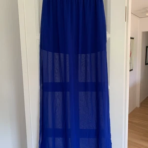 Kjol  - En lång kjol som har två slitar på varje sida på benet. 