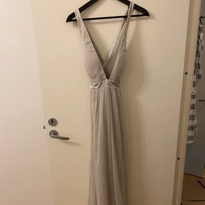 Fin grå maxiklänning - Superfin klänning till t.ex. bal! Använd en gång, har dock ett litet hål i tyllen längst ner, inget man tänker på om man inte vet om det men har därför valt att sänka priset. 
