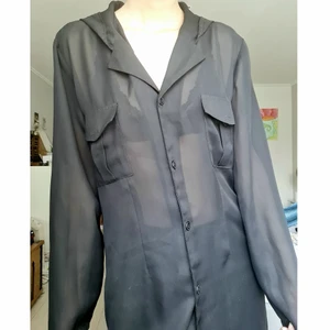 genomskinlig skjorta - Cool svart genomskinlig skjorta med huva, ganska lång! bortklippta lappar så vet inte vars den kommer ifrån eller storlek. Jag är en xs/s och såhär sitter den på mig, ganska oversize, passar nog många storlekar! Fint skick!