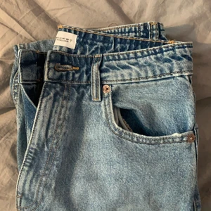 Blåa  high waisted zara jeans - Säljer ett par skit snygga highwaisted straight/mom jeans zara  pga att de var för korta i längden för mig som är runt 168 cm. Strl på jeansen är 38. Knappt använda. Om man kollar på andra bilden ser man att jag har sprätt upp de där nere för att göra de längre. 