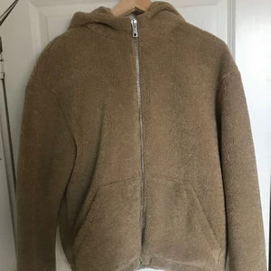 Teddyjacka - Säljer min teddyjacka då den inte är min stil längre. Den är väldigt sparsamt använd. Den har två fickor framtill och wen silvrig kedja samt en stor luva. Storlek 40