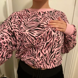 Zebra mönstrad rosa croppad tjocktröja - Tjocktröja med zebra mönster på. Den är adjustbar beroende på hur tajt du vill att den sitter vid midjan men annars lite lätt oversized vid ärmarna. 