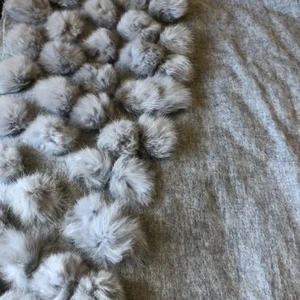 Cape/ halsduk från Born in Stockholm - En ljusgrå cape/ (halsduk) från Born in Stockholm. Äkta pälsbollar. Aldrig använd. Ord pris 999:-, mitt pris 500:-.