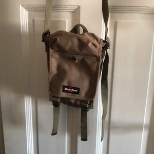 Eastpak väska - Eastpak. Militär brun. Aldrig använd. Långa snören som är justerbara. Ca 20 cm lång. 