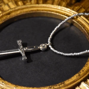Halsband svärd - Halsband med silvriga pärlor och ett maffigt silvrigt svärd. 
