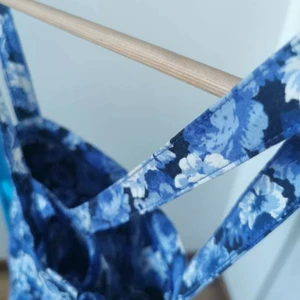 Blommig crop top  - SafirBlå crop top med blommig detalj och korsad ryggband, perfekt inför sommaren!