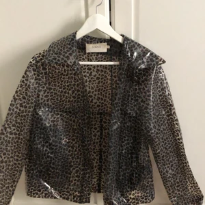 Stand copenhagen leopard regnjacka - STAND copenhagen regnjacka i transparang Leo mönster. Den vita avtagbara pälskragen kan man få med.