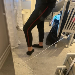 Svarta jeans med röda ränder  - Säljer nu mina svarta jeans med röda ränder på båda sidorna av benet.
