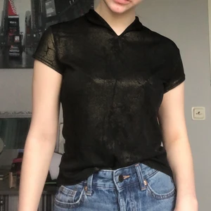 T-shirt med gul glitter mönster - En T-shirt med lite glitter mönster, Står inget på den hur stor eller var den är i från men skulle tro att den är i storlek S