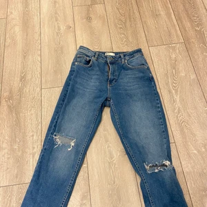 Gina tricot jeans storlek 38 - Säljer nu mina fina Gina jeans då de Tyvär blivit förkorta för mig som är 170 cm. De är ett par mom jeans och är i bra skick. Storlek 38. 