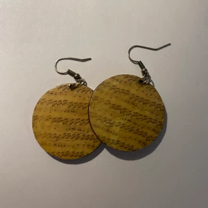 Örhängen - Runda trä örhängen med noter.