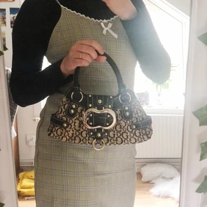 Guess handväska - Säljer min fina vintage Guess väska, köpt second hand. Är i jätte bra skick med några små skrapor (I bild 3 finns det en liten fläk markerad). Dustbag medföljer. BUDDGIVING på varan!💗