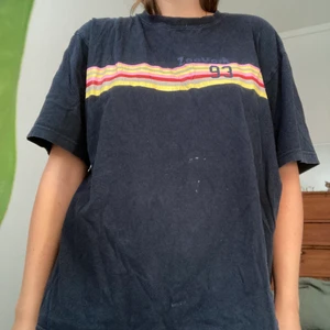T-shirt med färgklick - Lite oversized marinblå t-shirt med en nice färgklick. Storlek L men passar andra storlekar beroende på önskad passform. Köpt second han med den är i bra skick! 