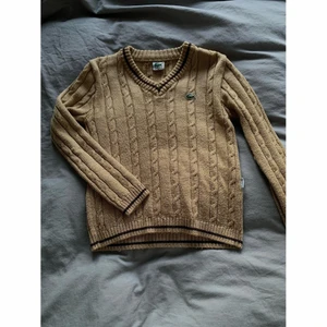 Stickad tröja från Lacoste - Stickad tröja från Lacoste med en v-rigning. Bra skick, storlek M men storlek stämmer inte riktigt. XS/S är det rätta. Finns i Växjö att mötas upp annars tillkommer frakt🤍 endast swish!